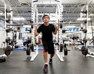 Senior Skyler Stefanski concentrates on his balance and core as he does some barbell lunges during a beginning weight training class at Lincoln East. KRISTIN STREFF, Journal Star