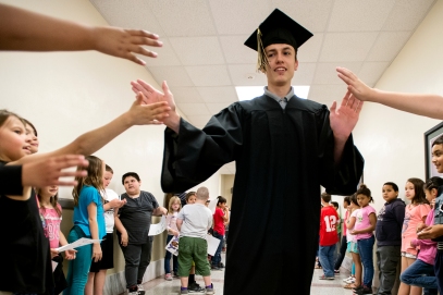 Lincoln Southeast graduate and Hartley Elementary alum Joshua Erb collects high fives from young students cheering him on during a graduate celebration at Hartley Elementary. KRISTIN STREFF, Journal Star